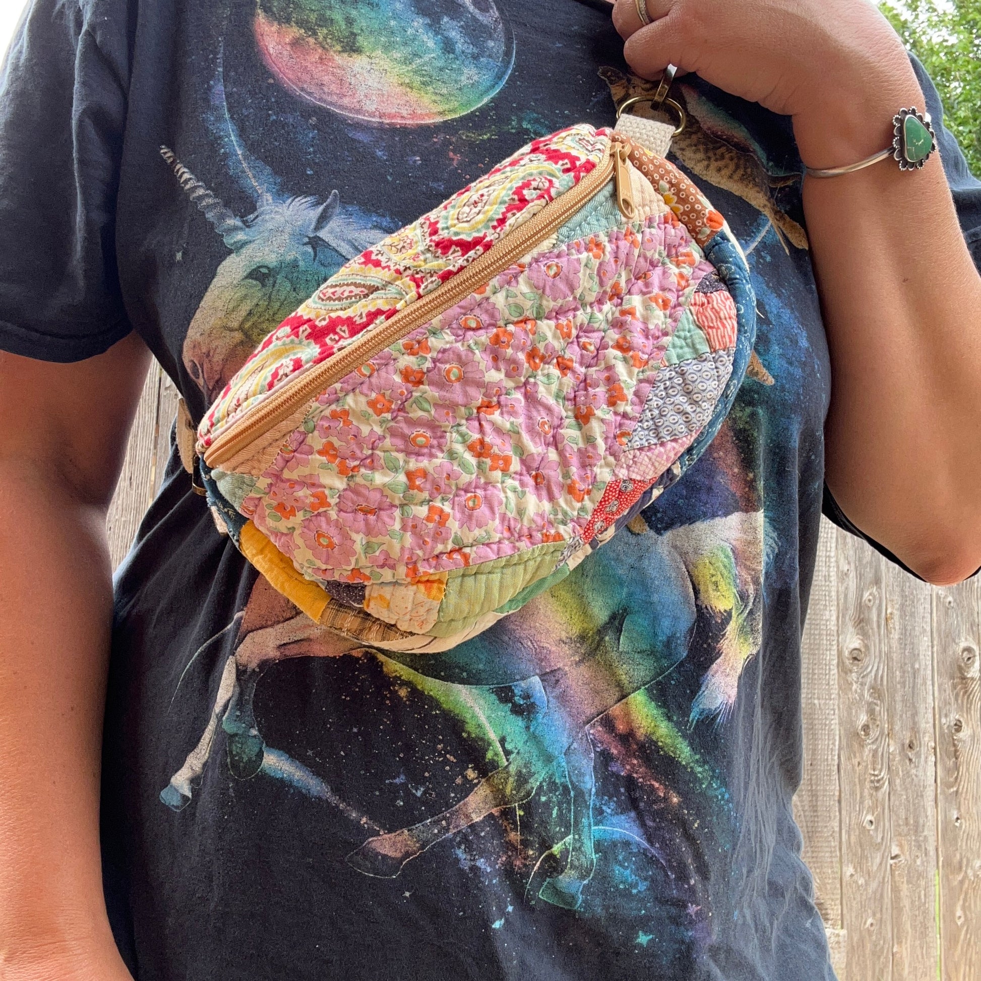 Person wearing a colorful floral-patterned bag over their shoulder with a graphic t-shirt.